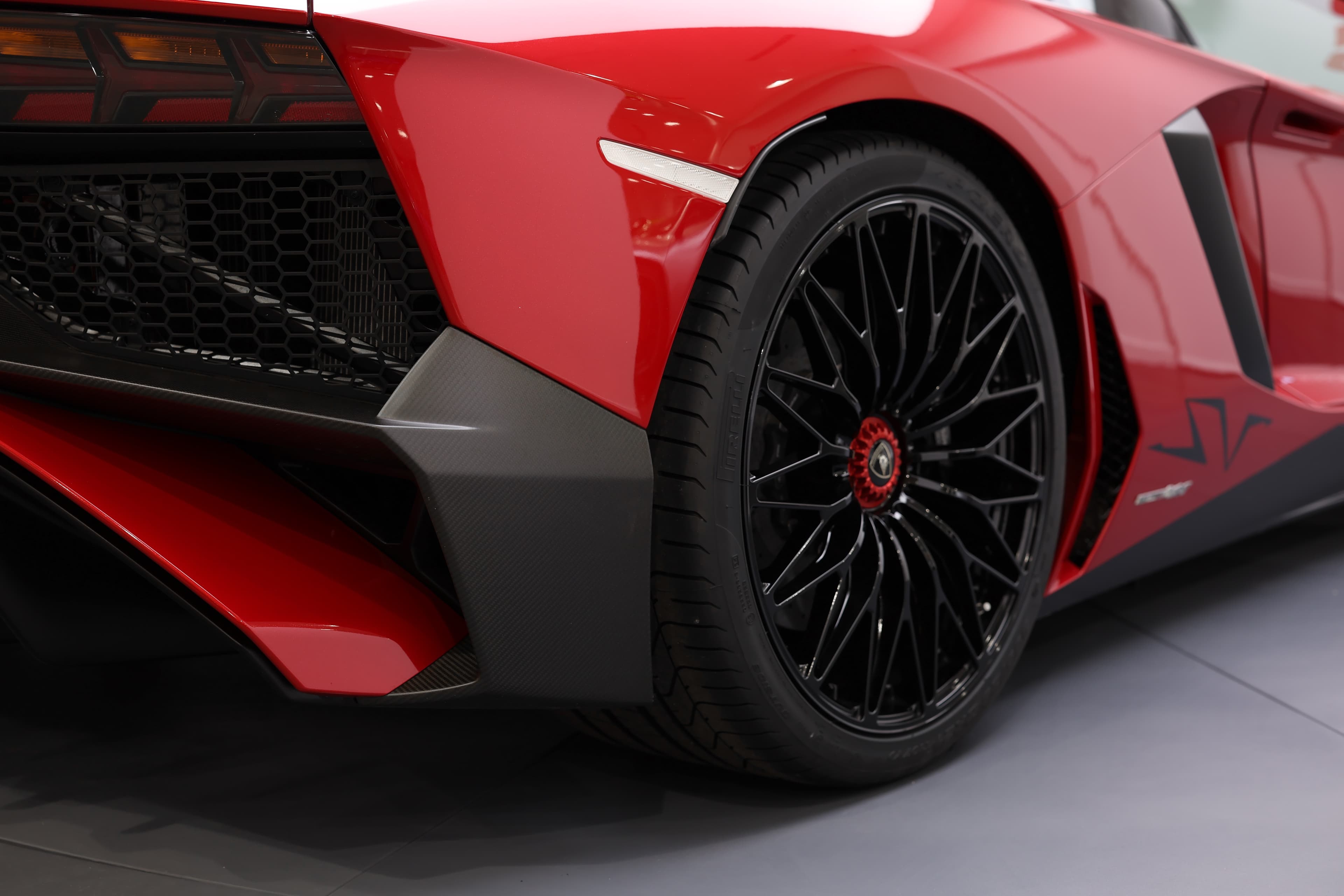 Détail sur le côté de la Lamborghini Aventador SV, mettant en avant la jante audacieuse et le Déflecteur en carbone qui accentuent son allure sportive, tout en jouant un rôle crucial dans l'aérodynamisme de la voiture.