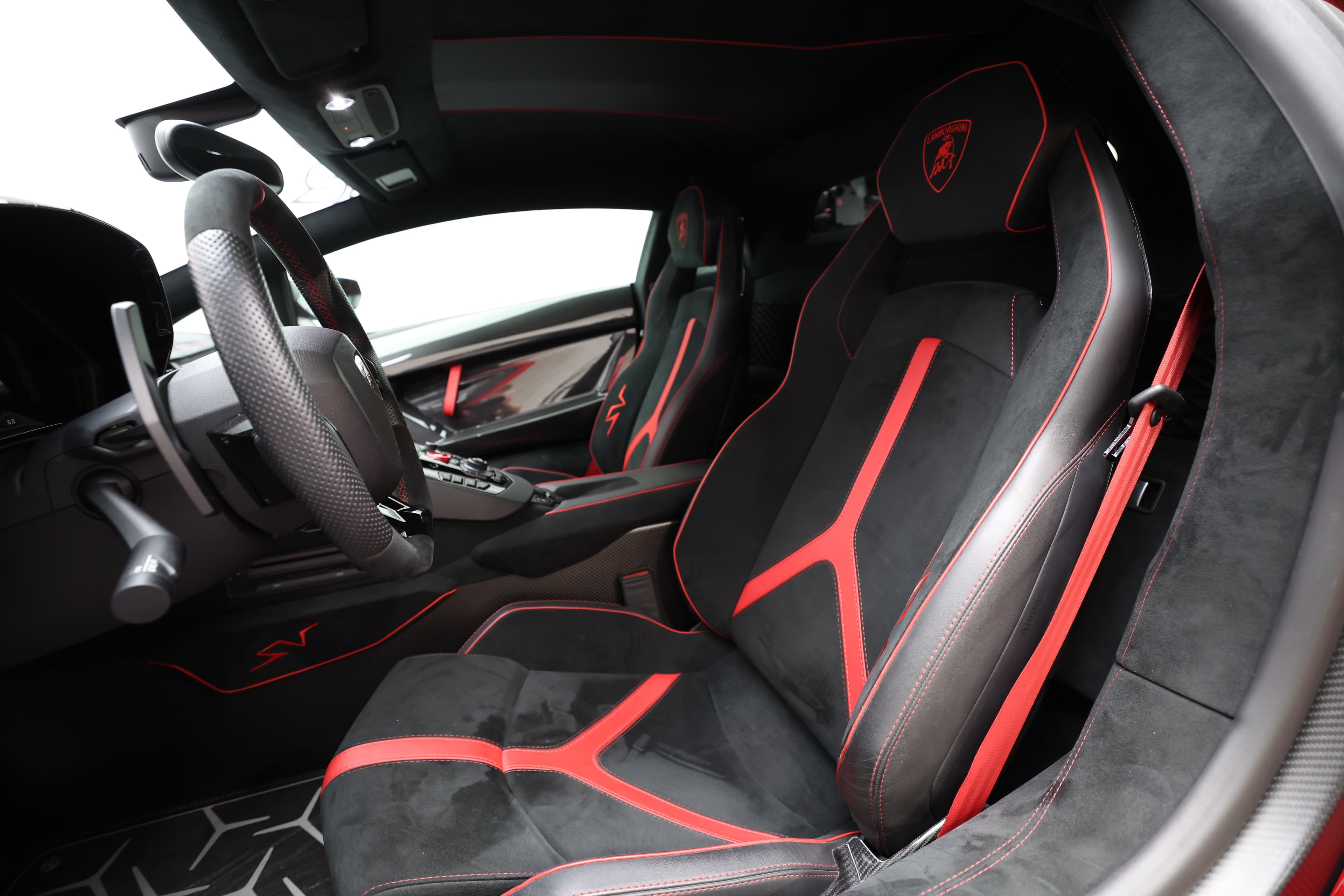 Explorez davantage l'intérieur de la Lamborghini Aventador SV, où chaque détail, des sièges sport aux finitions en carbone, crée une ambiance à la fois luxueuse et orientée vers la performance. La disposition ergonomique des commandes assure une expérience de conduite immersive.