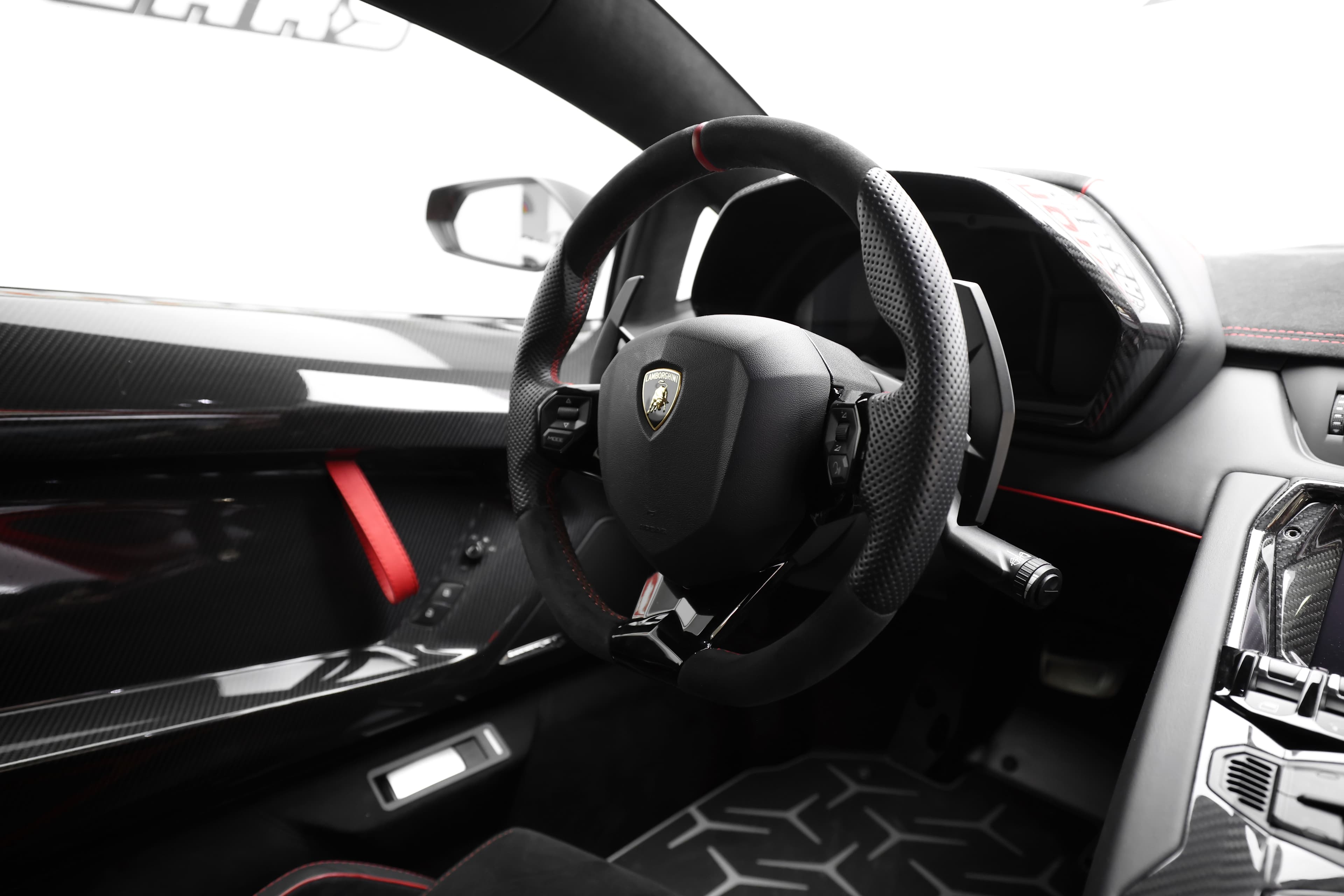 Volant en carbone et intérieur raffiné de Lamborghini, combinant technologie moderne et design sportif.