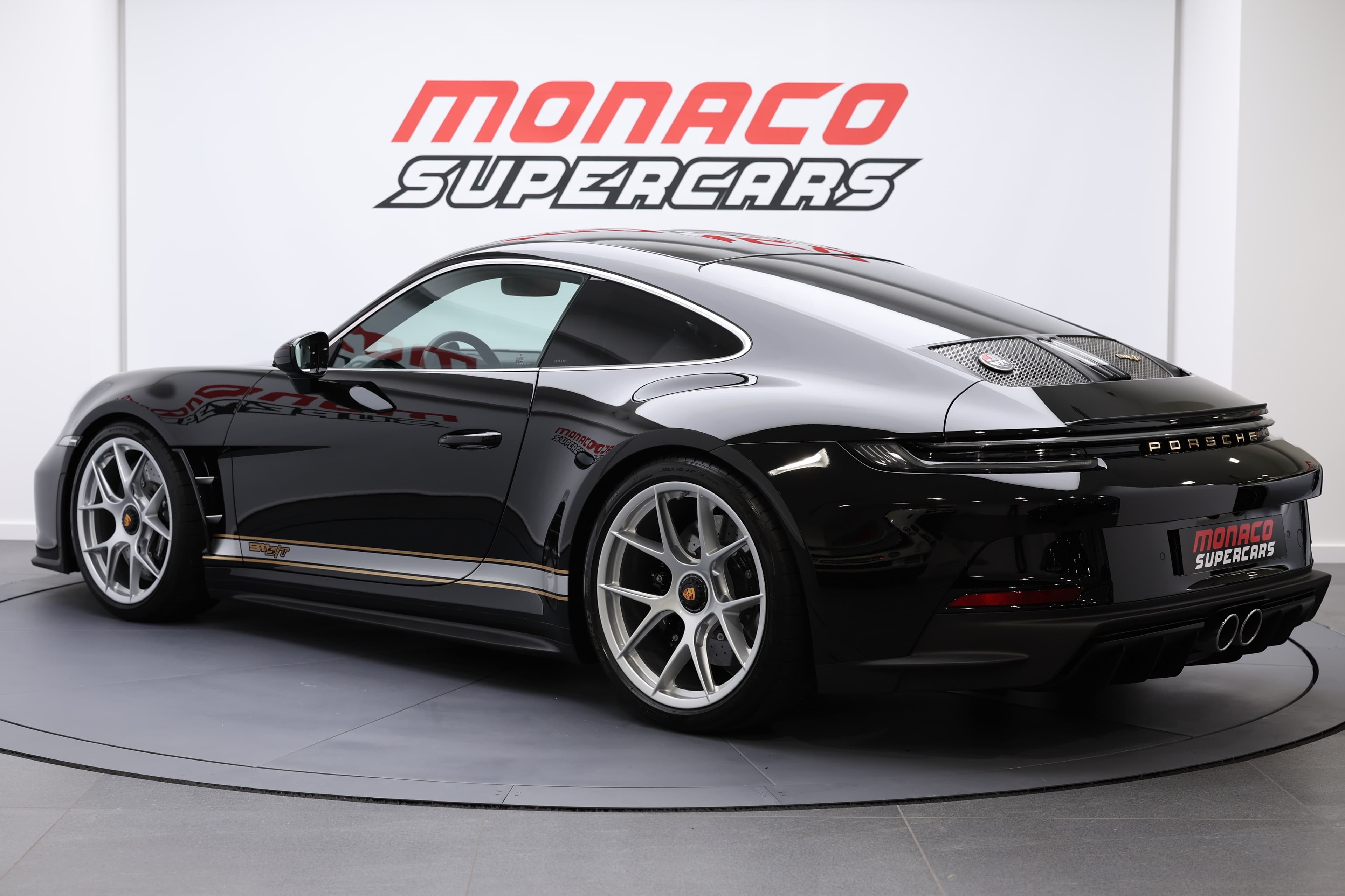 Porsche 911 en noir, vue arrière, mise en valeur à Monaco Supercars, alliant performance sportive et design raffiné, parfaite pour les amateurs de voitures d'exception.