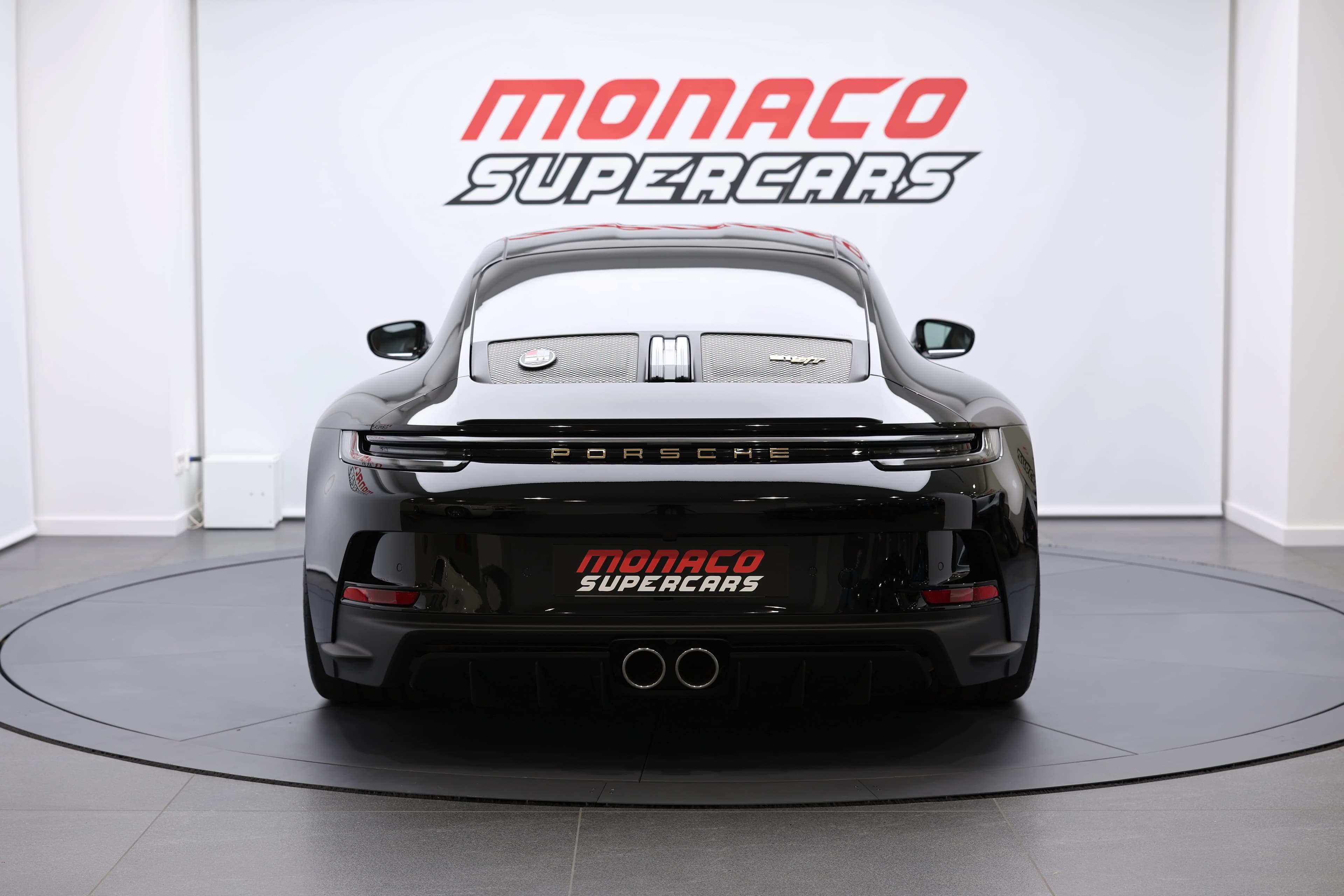 Porsche 911 en noir, vue arrière, mise en valeur à Monaco Supercars, alliant performance sportive et design raffiné, parfaite pour les amateurs de voitures d'exception.