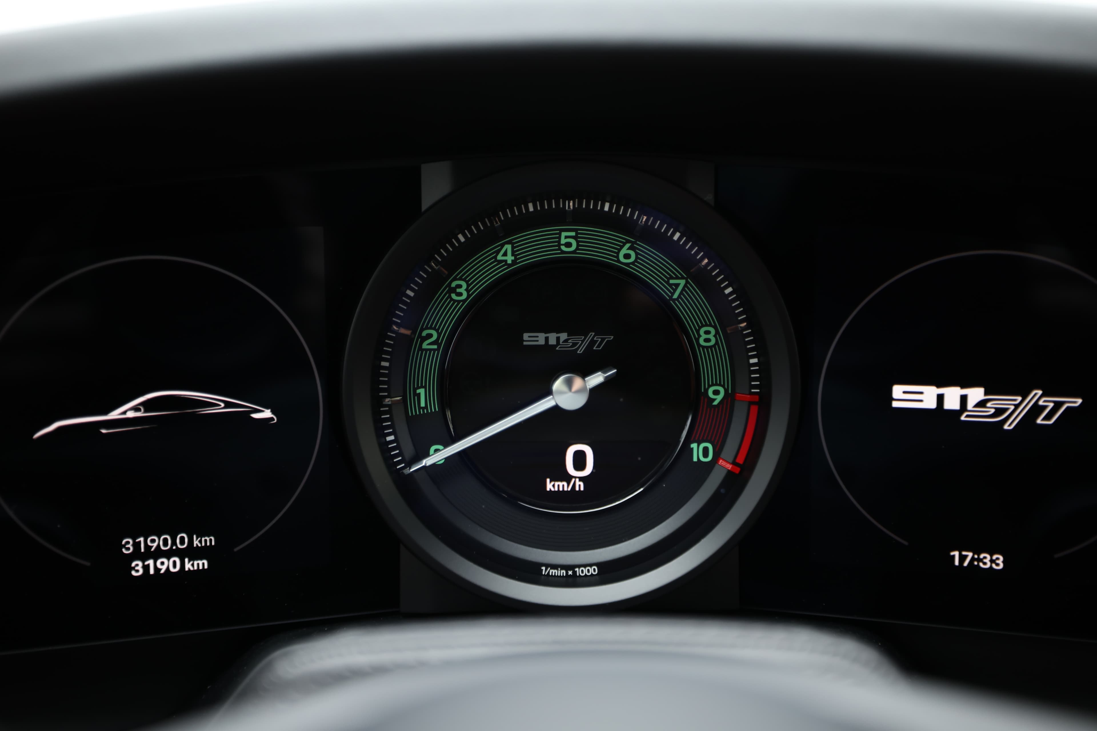 Tableau de bord de la Porsche 911 avec un compteur de vitesse clair et précis. On y voit le kilométrage de 3190 km. Le design est à la fois moderne et fonctionnel, reflétant l'esprit sportif de la voiture.