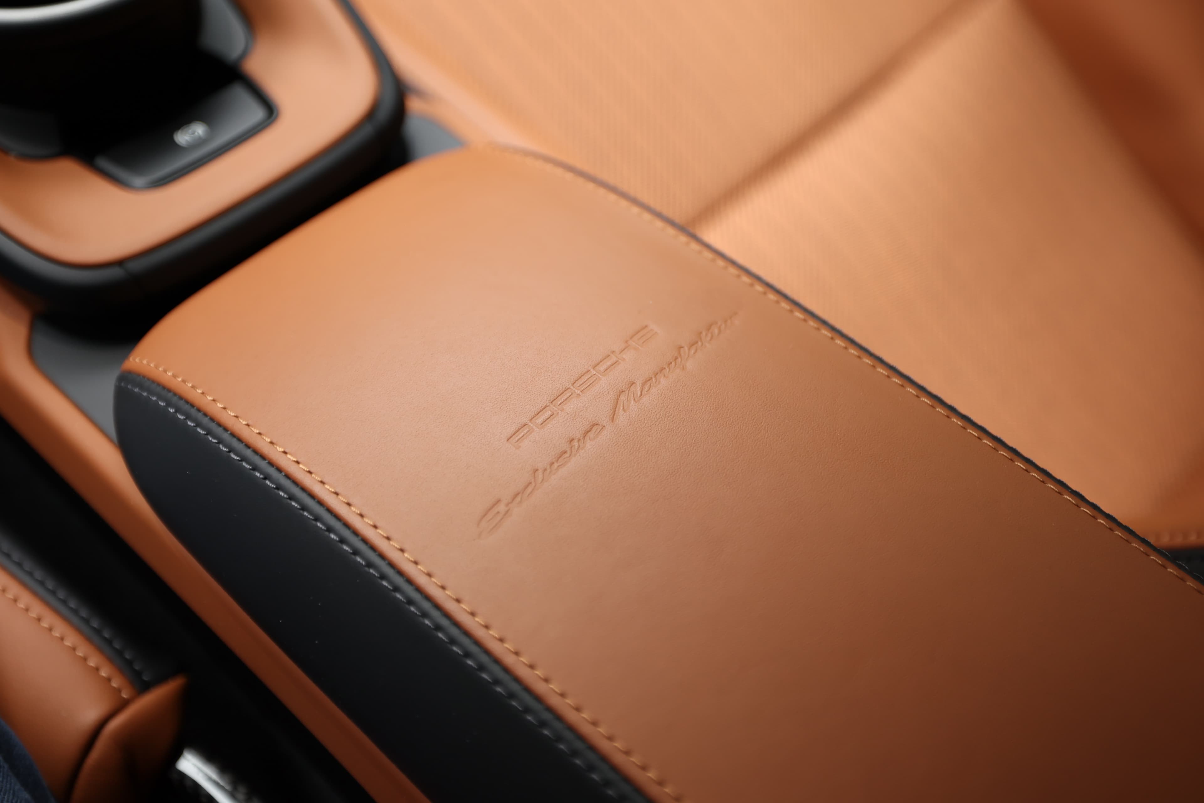 Détail du repose-bras en cuir de la Porsche 911. La texture est luxueuse, avec le logo Porsche subtilement embossé, ajoutant une touche d'élégance. Ce design améliore le confort tout en renforçant le caractère haut de gamme de l'intérieur.