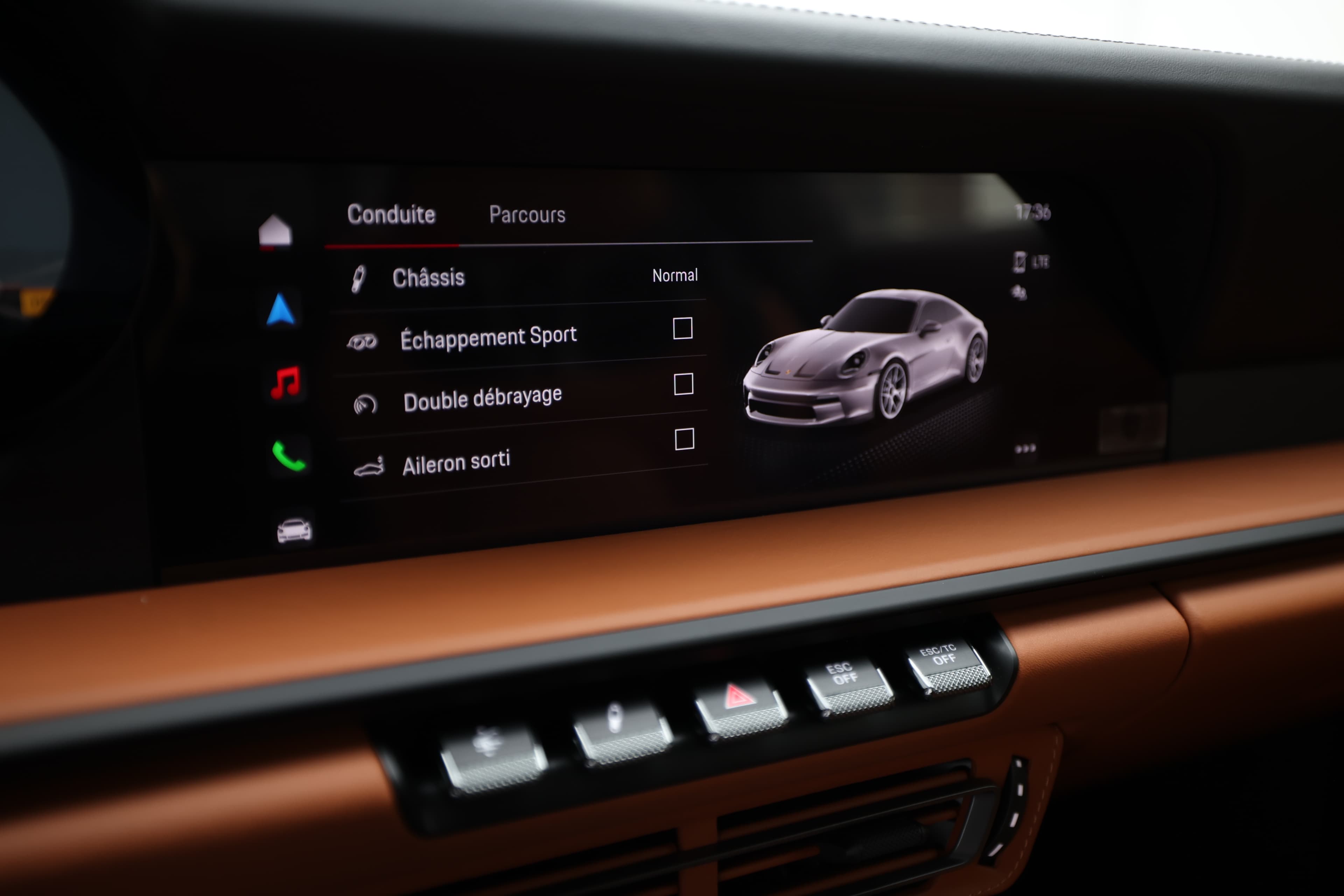 Écran d'affichage central de la Porsche 911, montrant les options de conduite. On y trouve des réglages pour le mode de conduite, l'ensoleillement, et l'alarme. L'interface est intuitive, combinant technologie moderne et design élégant.