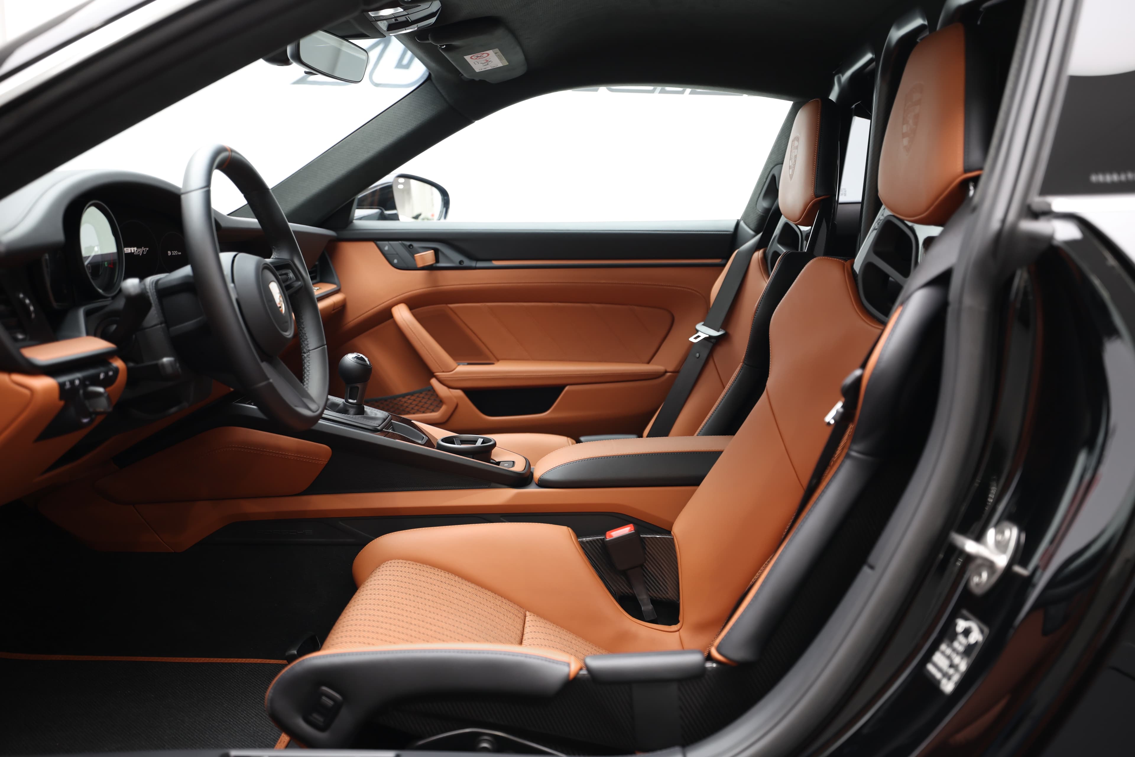 Explorez l'intérieur sportif et élégant, mettant en avant des sièges en cuir orange et un design ergonomique, créant une atmosphère de performance et de confort inégalé.