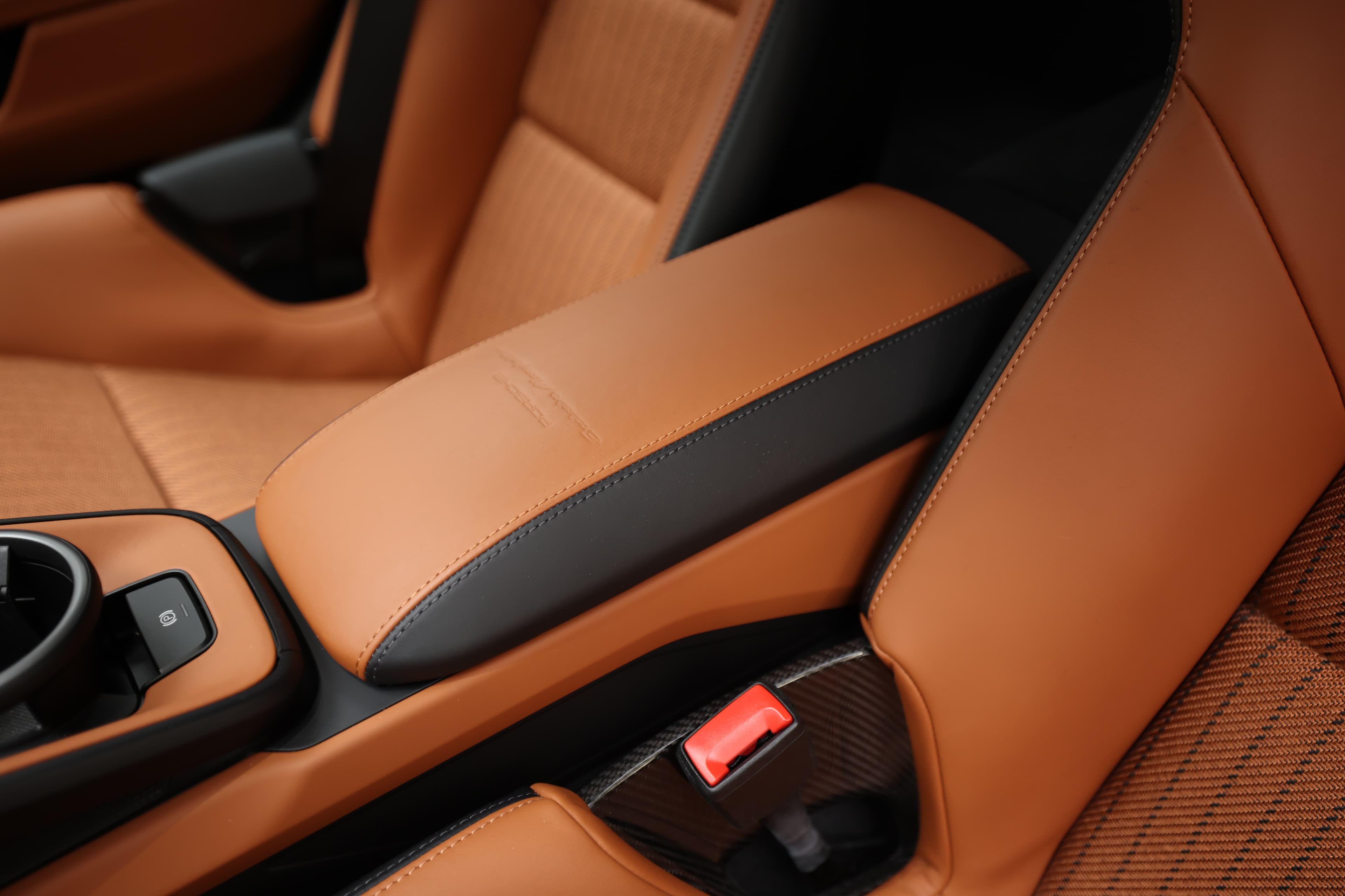 **Description** : Détail du repose-bras en cuir, combinant des accents orange et noir, offrant un confort supplémentaire et une touche de sophistication à l'intérieur de la voiture de sport.   Si tu as besoin d'autres précisions ou d'images, n'hésite pas à demander !
