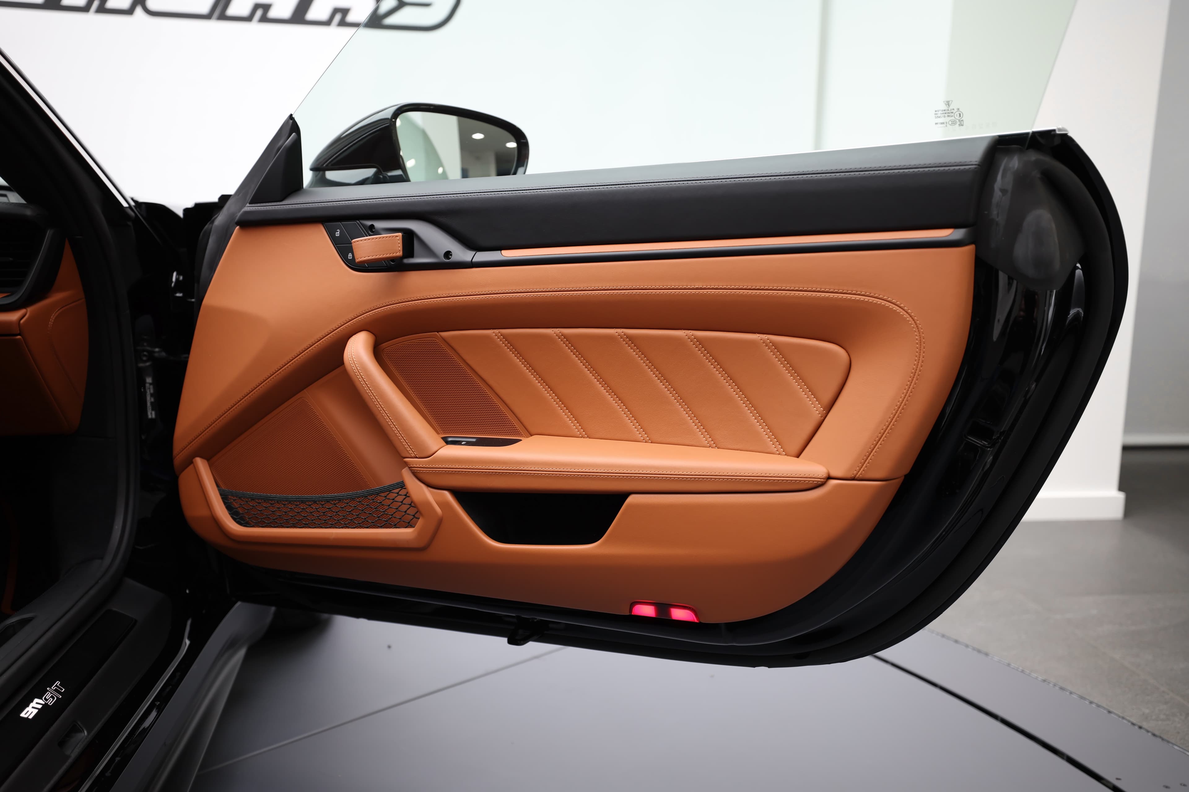 Une portière au design audacieux, mettant en avant des accents orange vif et des matériaux de qualité, offrant une combinaison parfaite de style et de fonctionnalité dans cet intérieur haut de gamme.