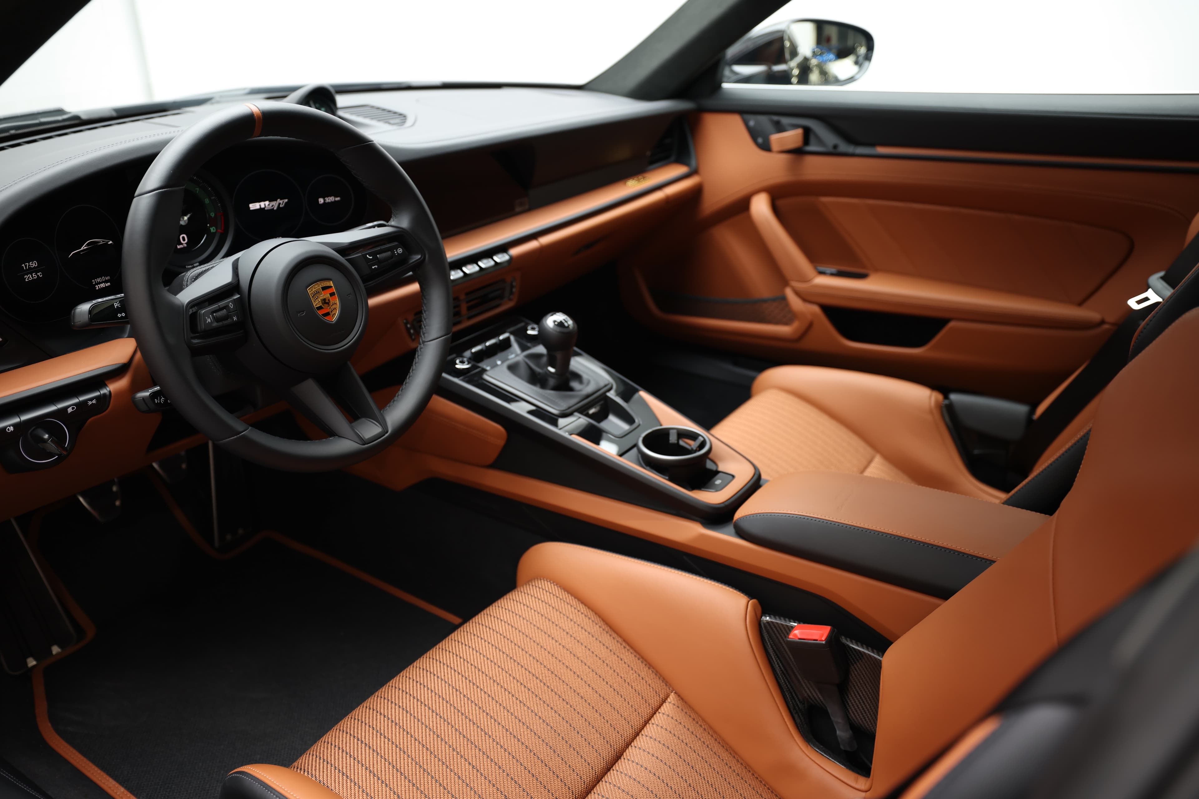 Un habitacle spacieux et raffiné, combinant des sièges en cuir orange, un tableau de bord moderne et des commandes intuitives, créant une atmosphère de luxe et de performance exceptionnelle pour chaque trajet.